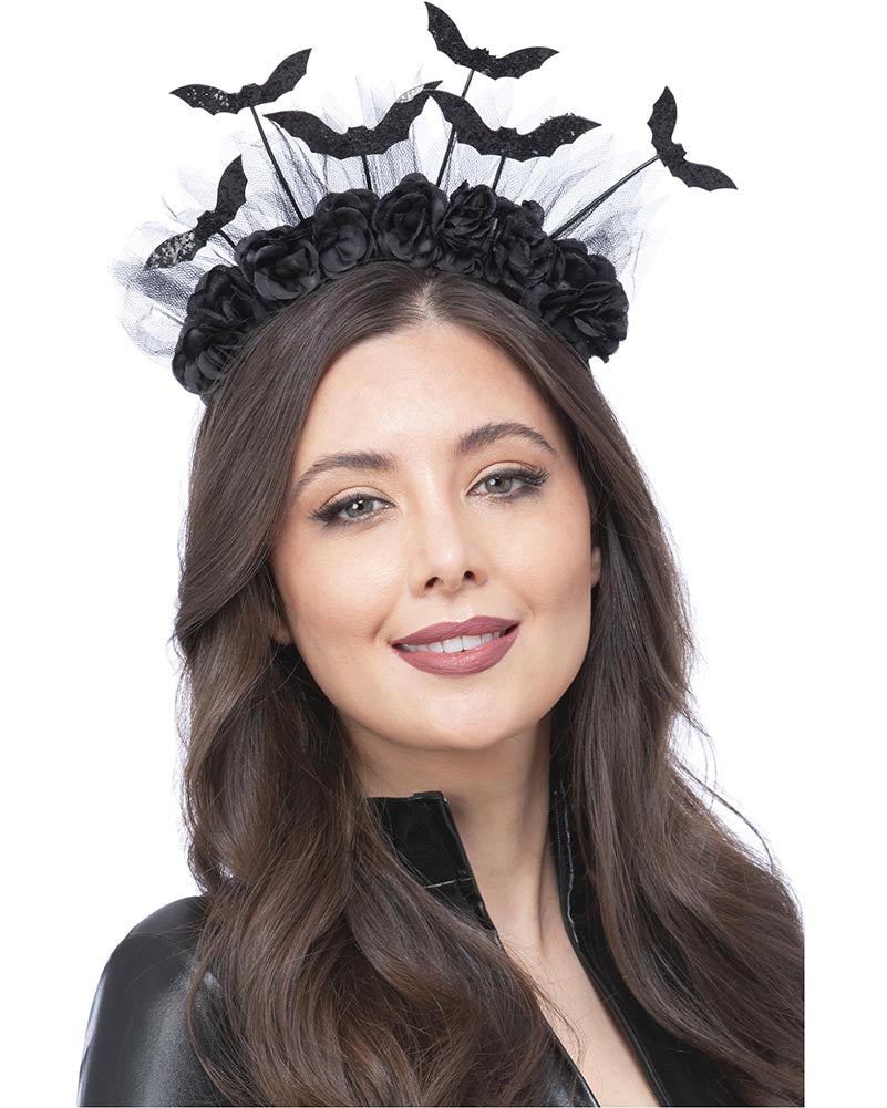 Woman wearing a black floral headpiece with bats on a white background