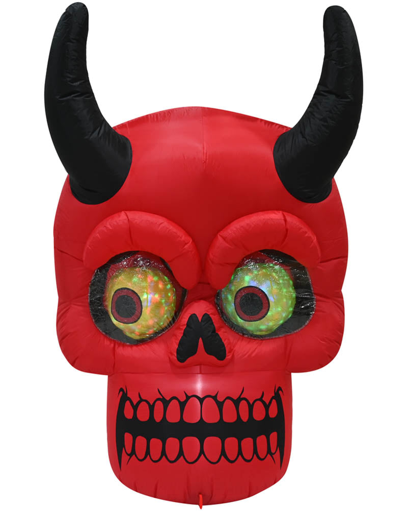 Red inflatable devil skull Halloween decoration with black horns, black nose and mouth details, and large green glittery eyes on a white background.