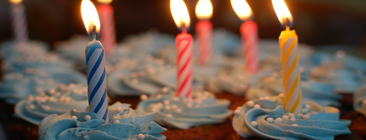 Image of cupcakes with blue icing and candles. 