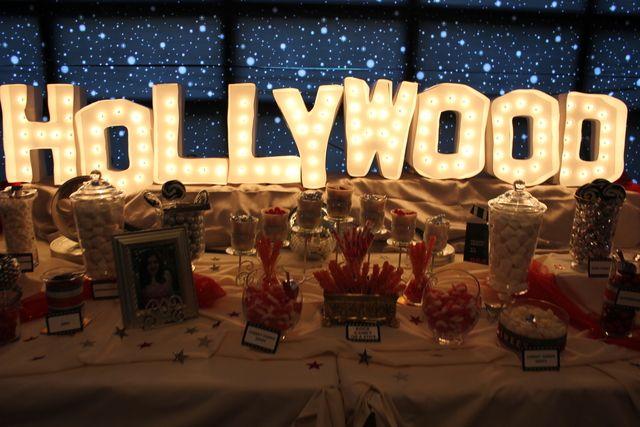 Image of light up Hollywood sign behind table of food. 