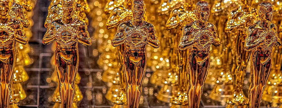 Image of lots of gold Oscar statues all lined up.