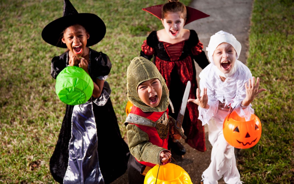Image of four kids dressed as a witch, vampire, knight and zombie. 