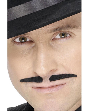 Close-up of a person wearing a black top hat with a white stripe and a black mustache.