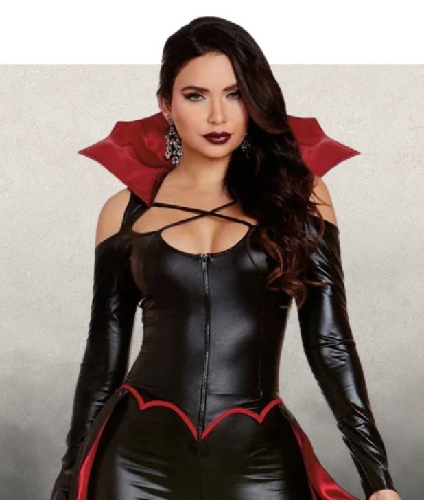 A woman wearing a black and red vampire costume on a beige background. Click to shop all Vampire Halloween costumes. 