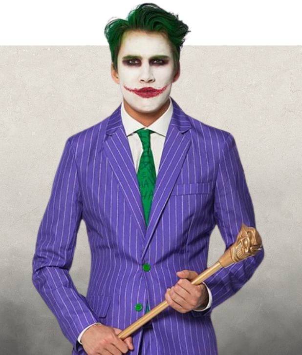 A man wearing a Joker Halloween Costume on a beige background. Click to shop all Joker Costumes. 