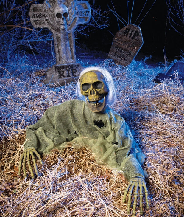 a zombie skeleton in a garden with grave stones in the back. Click to shop all Halloween Decor Kits