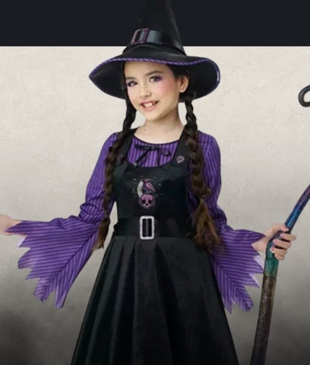 A beige background with black fog at the bottom. Features a Girls Witch character. Click to shop all Wicked Witches Costumes and accessories.
