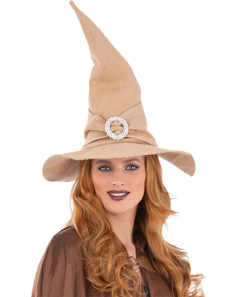 Woman wearing a tan witch hat with a decorative brooch on a white background