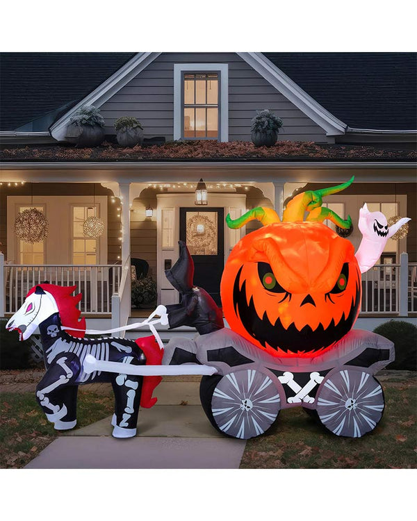 Halloween inflatable with a pumpkin and skeleton horse and carriage in front of a house.