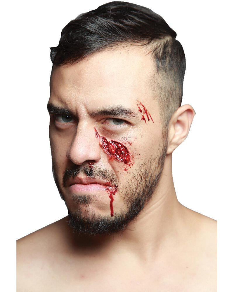 Man with makeup resembling a bloody wound on his face against a white background