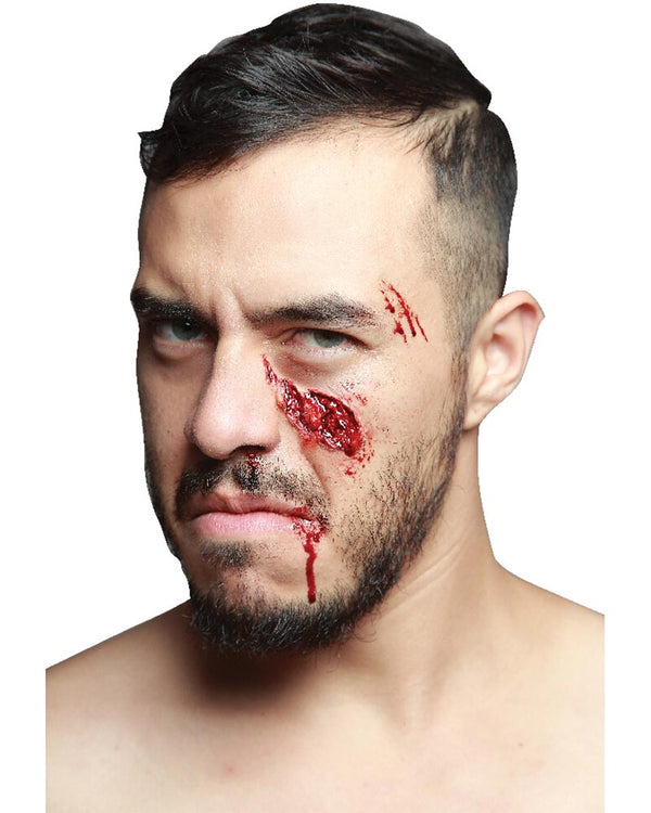 Man with makeup resembling a bloody wound on his face against a white background