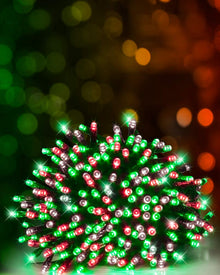 A cluster of multicolor LED holiday lights in red, green, and silver, glowing brightly against a dark background with warm bokeh lights.