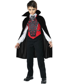 Child wearing a vampire costume with a black cape, red vest, and black pants on a white background