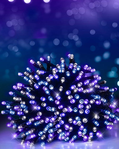 A bundle of Christmas string lights glowing with purple and blue lights, set against a dark blue bokeh background.