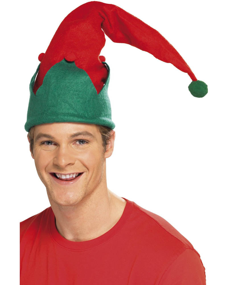 A smiling man wearing a red and green elf hat with a long pointed red brim and a green pom-pom, against a plain white background.