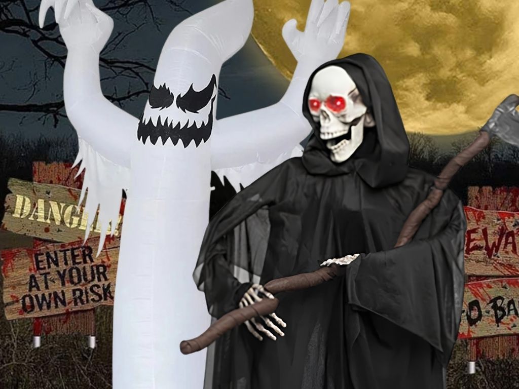 An inflatable white ghost with a sinister face standing next to a Grim Reaper figure holding a scythe, set against a dark night sky with full moon and a wooden "DANGER! ENTER AT YOUR OWN RISK" sign. Click to shop all Halloween Decorations.