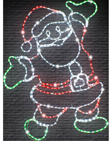 A Santa Claus figure outlined with multicolor LED light strips against a dark gray brick wall background.