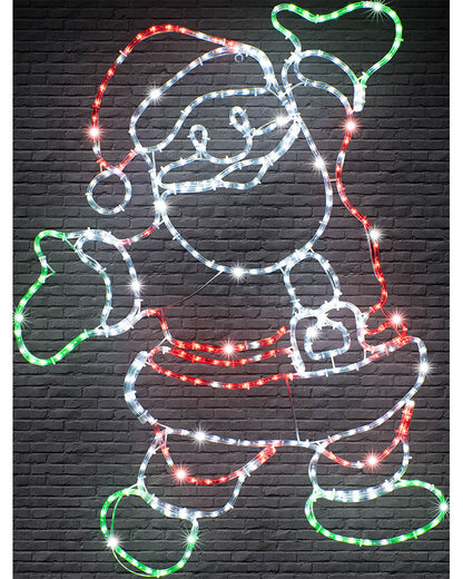 A Santa Claus figure outlined with multicolor LED light strips against a dark gray brick wall background.