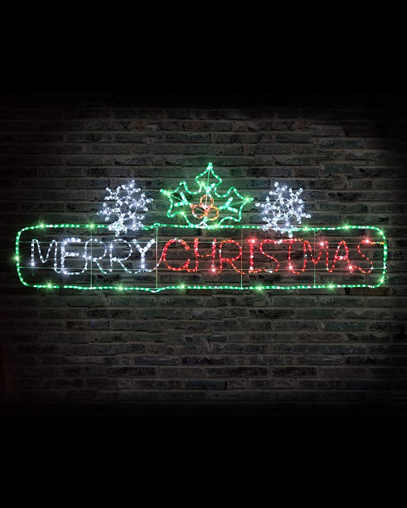 A festive LED light sign spelling out 'MERRY CHRISTMAS' in red, white, and green lights, decorated with snowflakes and a Christmas tree on a dark brick wall background.