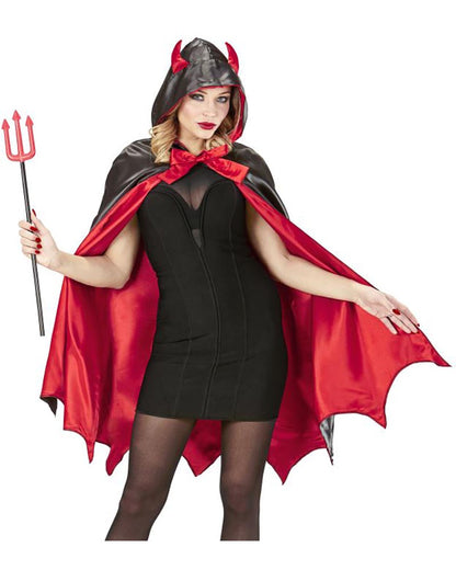 Person wearing a devil costume with a red cape and black outfit, holding a pitchfork.