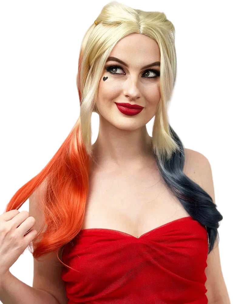 A woman modeling a blonde wig with a bright orange-red side section and a dark blue-gray side section, styled in a half-up top bun. She is wearing a red strapless top against a plain light background.