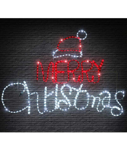 LED light sign spelling 'MERRY Christmas' with a Santa hat at the top, shown against a dark brick wall background.