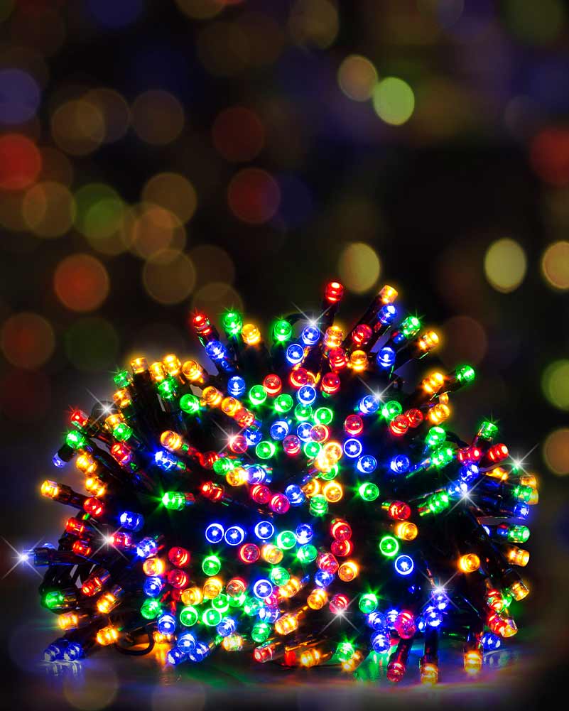 A bundle of multicolor Christmas string lights glowing with red, green, blue, orange, and yellow lights, set against a dark background with colorful bokeh.