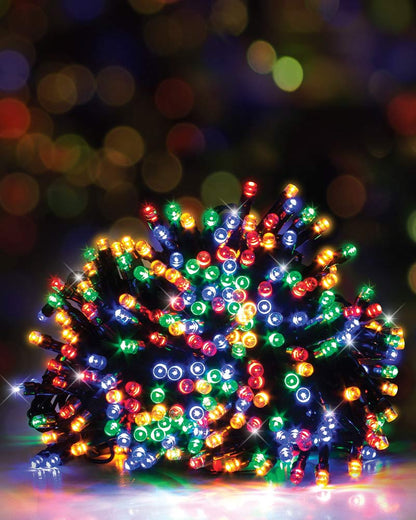 A bundle of multicolor Christmas string lights glowing with red, green, blue, orange, and yellow lights, photographed against a dark blurred bokeh background.