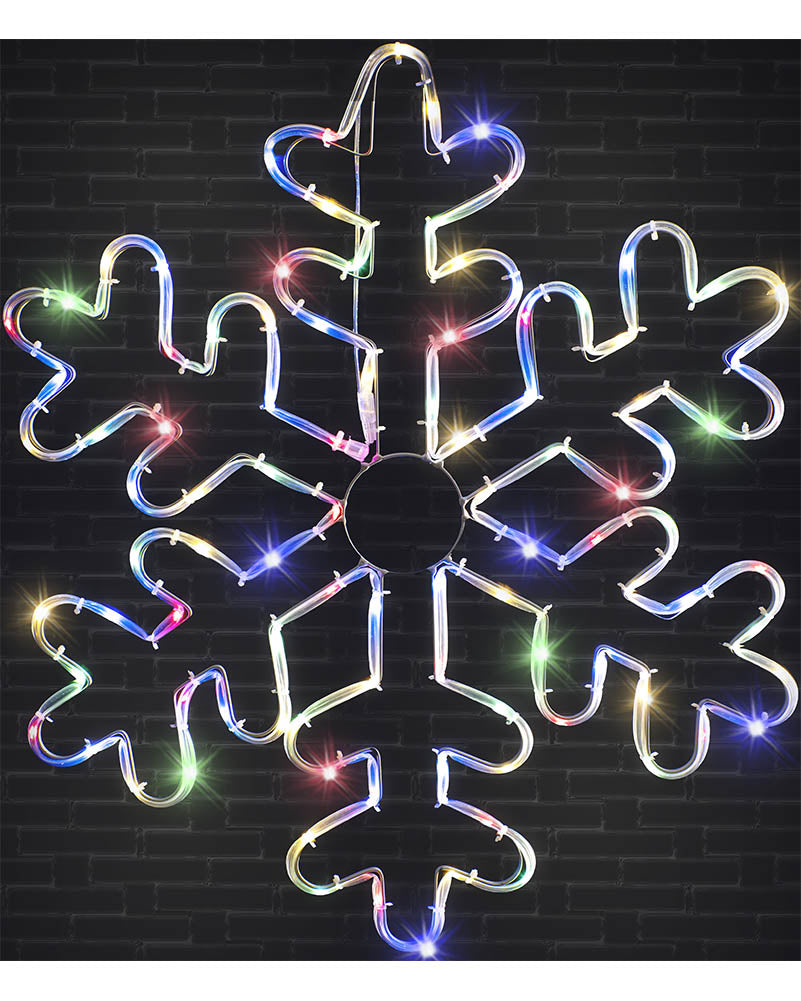 A large snowflake-shaped LED light decoration with multicolored glowing lights, shown against a dark brick wall background.