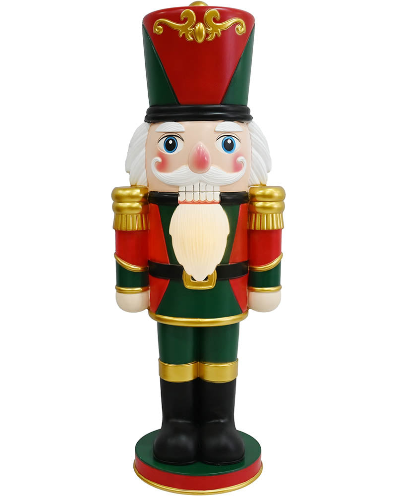 A traditional Christmas nutcracker figurine standing on a white background. The nutcracker is dressed in a red and green uniform with gold trim, a red and green tall hat, a white beard, and black boots.