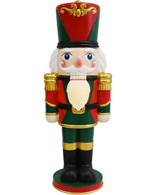 A traditional Christmas nutcracker figurine standing on a white background. The nutcracker is dressed in a red and green uniform with gold trim, a red and green tall hat, a white beard, and black boots.