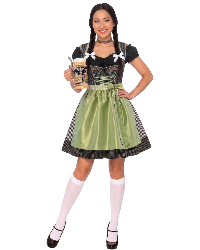 A woman modeling a traditional German dirndl costume against a plain white background. The costume features a black bodice with white lace-up details, a shiny olive green skirt, and black-and-white checkered side panels.