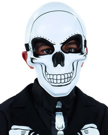 A child wearing a white skeleton design half mask with eye openings, and black clothing.