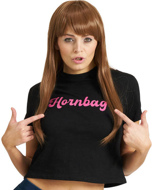Woman wearing a brown wig with black t-shirt with 'Hornbag' in pink text, pointing at herself.