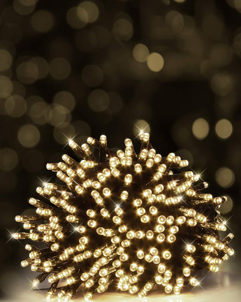 A bundle of warm white LED string lights glowing brightly against a dark, softly blurred bokeh background.
