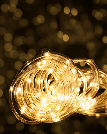 Coiled warm white LED fairy string lights glowing against a dark background with golden bokeh.