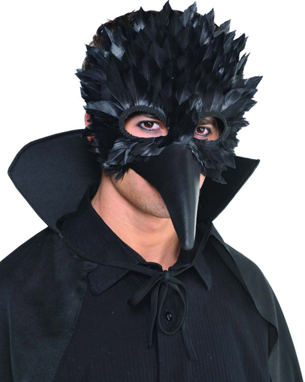 Image of man wearing black feathered crow eye mask. 