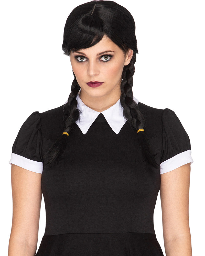 A person wearing a Gothic Girl Deluxe Plaited Black Wig with thick plaits and a side-parted front fringe, styled to resemble a character from the Addams Family.